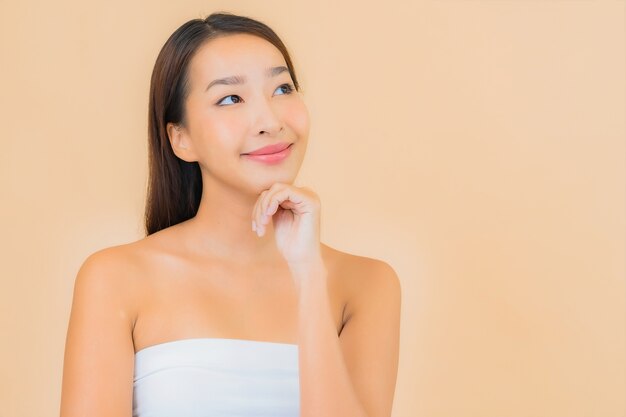 Portrait belle jeune femme asiatique dans un spa avec maquillage naturel sur beige