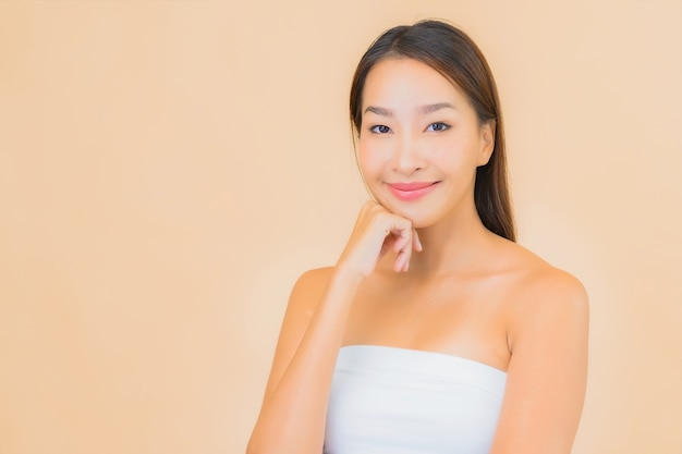 Portrait belle jeune femme asiatique dans un spa avec maquillage naturel sur beige