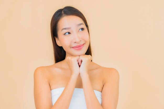 Portrait belle jeune femme asiatique dans un spa avec maquillage naturel sur beige