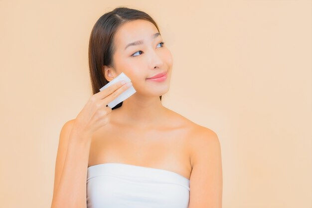 Portrait belle jeune femme asiatique dans un spa avec maquillage naturel sur beige