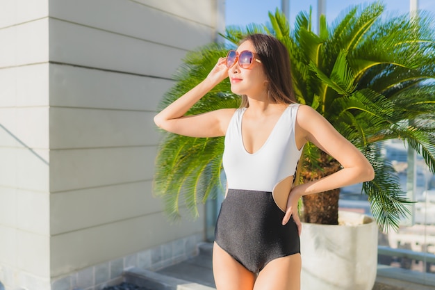 Portrait belle jeune femme asiatique détend les loisirs autour de la piscine