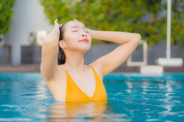 Portrait belle jeune femme asiatique de détente en plein air dans la piscine en voyage de vacances