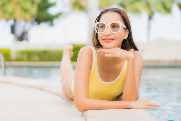 Portrait belle jeune femme asiatique de détente en plein air dans la piscine en voyage de vacances