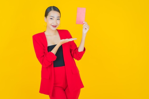 Portrait belle jeune femme asiatique avec enveloppe rouge sur jaune