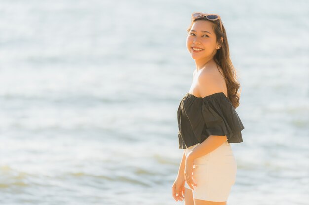 Portrait belle jeune femme asiatique heureuse et sourit sur la plage, la mer et l&#39;océan