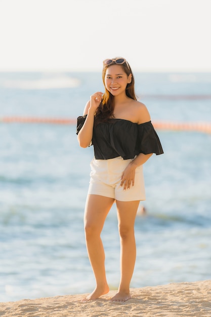 Portrait belle jeune femme asiatique heureuse et sourit sur la plage, la mer et l&#39;océan