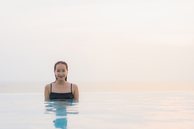 Portrait belle jeune femme asiatique heureux sourire se détendre autour de la piscine dans l&#39;hôtel resort