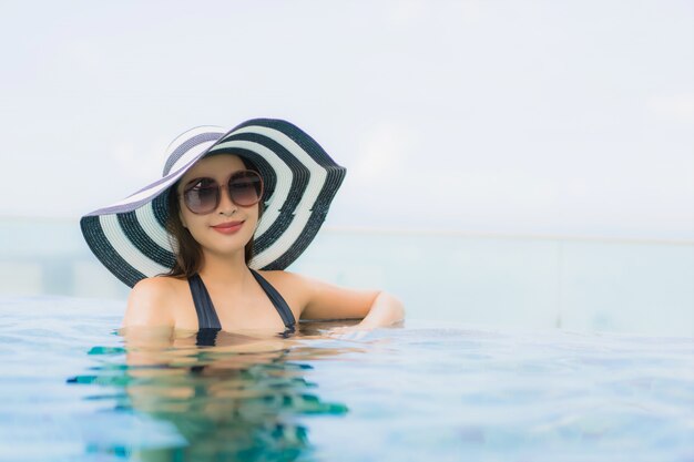 Portrait belle jeune femme asiatique heureux sourire se détendre piscine en plein air dans la station