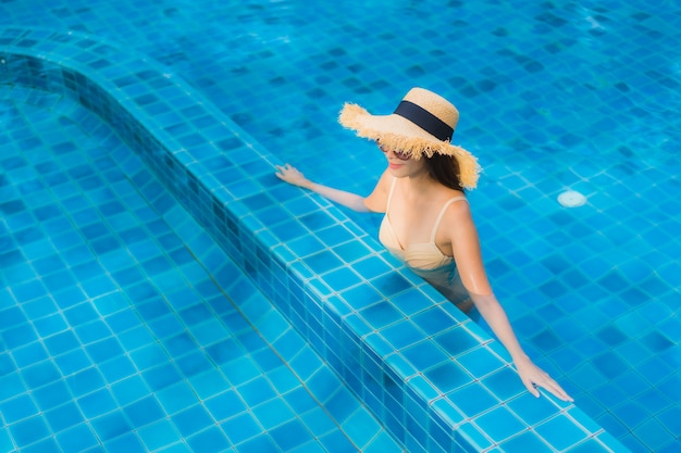 Portrait belle jeune femme asiatique heureux sourire se détendre piscine en plein air dans la station