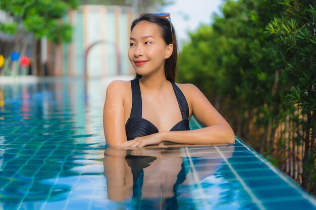Portrait belle jeune femme asiatique heureux sourire se détendre piscine en plein air dans la station