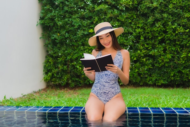 Portrait belle jeune femme asiatique lire le livre autour de la piscine