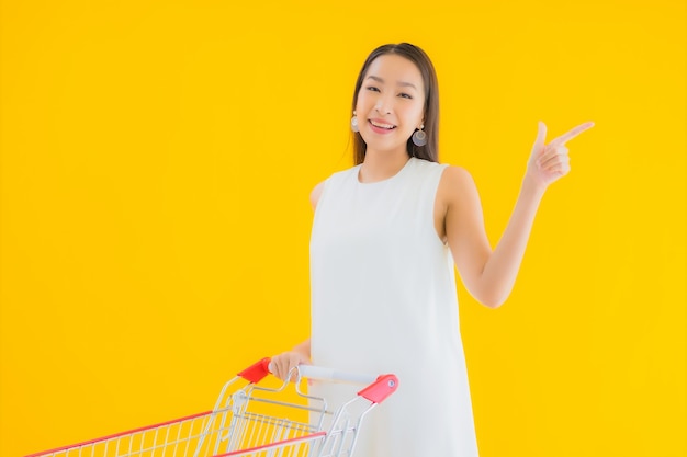 Portrait belle jeune femme asiatique avec panier d'épicerie pour faire ses courses au supermarché