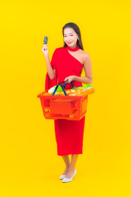 Portrait belle jeune femme asiatique avec panier d'épicerie de supermarché