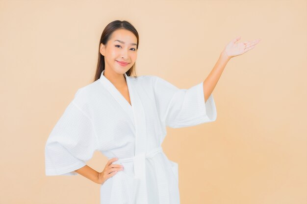 Portrait belle jeune femme asiatique portant peignoir avec sourire sur beige