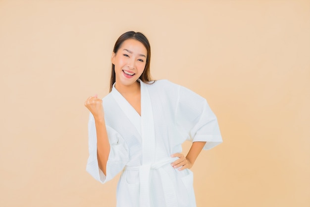 Portrait belle jeune femme asiatique portant peignoir avec sourire sur beige