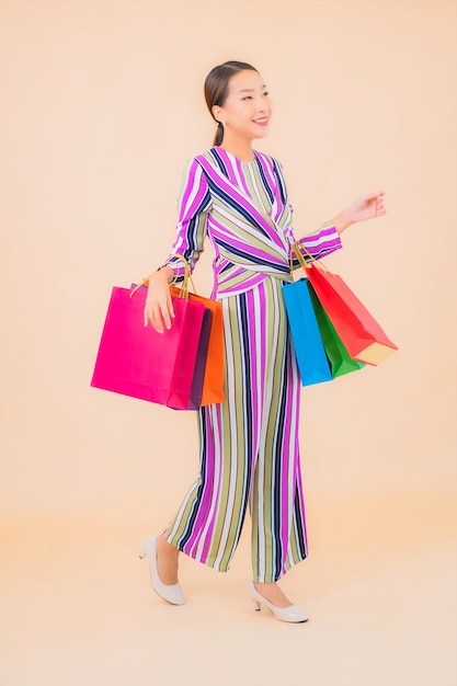 Portrait belle jeune femme asiatique avec sac à provisions coloré sur la couleur