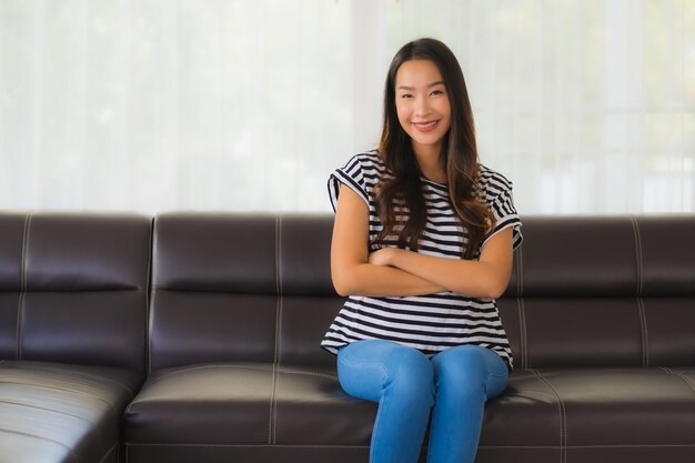 Portrait de la belle jeune femme asiatique se détend sur le canapé dans le salon