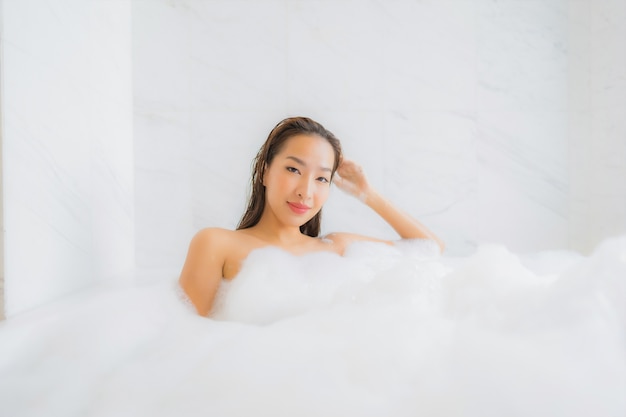 Portrait de la belle jeune femme asiatique se détend dans la baignoire