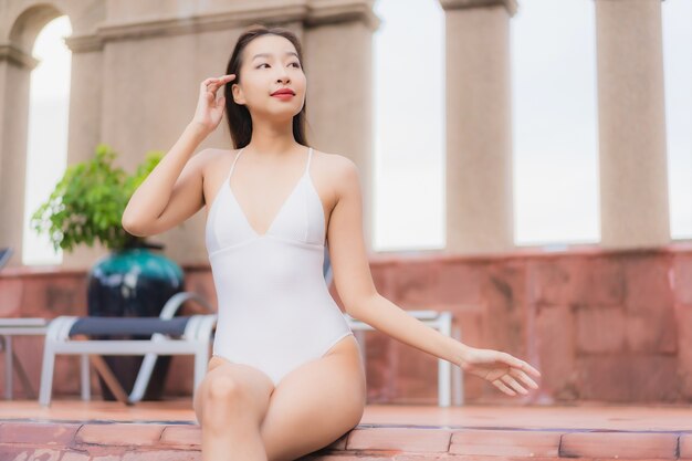 Portrait de la belle jeune femme asiatique se détend dans la piscine