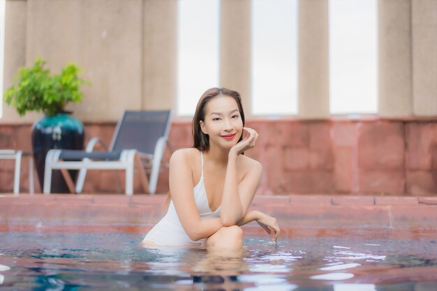 Portrait de la belle jeune femme asiatique se détend dans la piscine