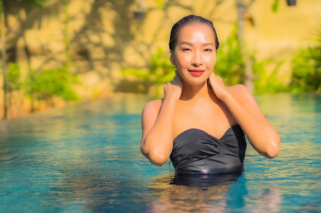 Portrait de la belle jeune femme asiatique se détend dans la piscine
