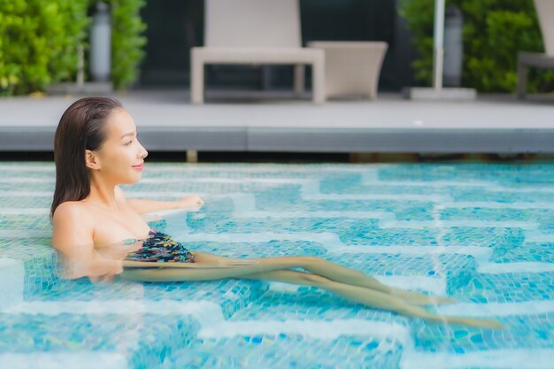 Portrait de la belle jeune femme asiatique se détend sur la piscine de l'hôtel resort