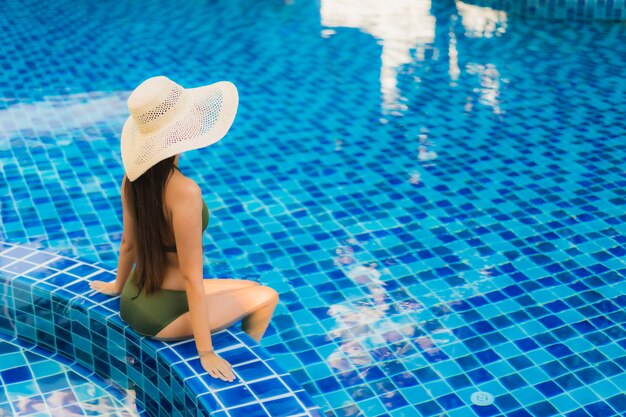 Portrait belle jeune femme asiatique se détendre autour de la piscine dans l'hôtel resort