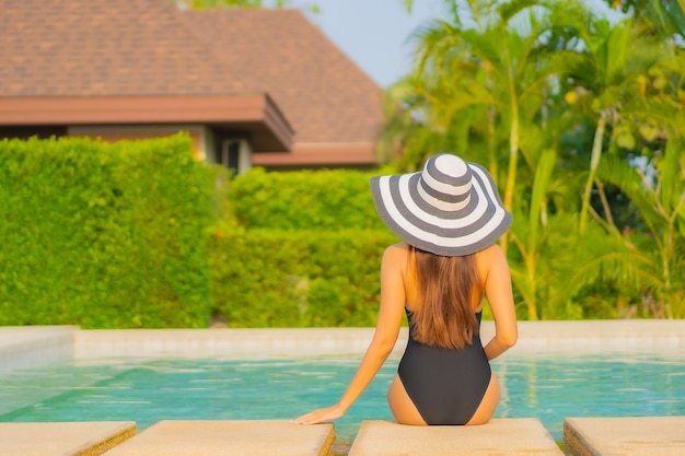 Portrait belle jeune femme asiatique se détendre autour de la piscine dans un hôtel de villégiature en vacances
