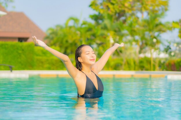 Portrait belle jeune femme asiatique se détendre autour de la piscine dans un hôtel de villégiature en vacances