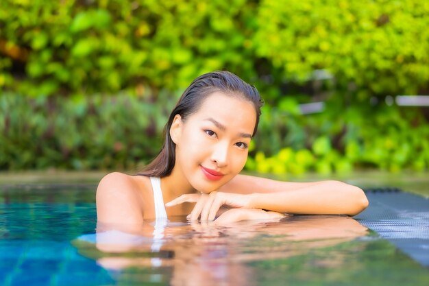 Portrait belle jeune femme asiatique se détendre autour de la piscine dans un hôtel de villégiature en vacances