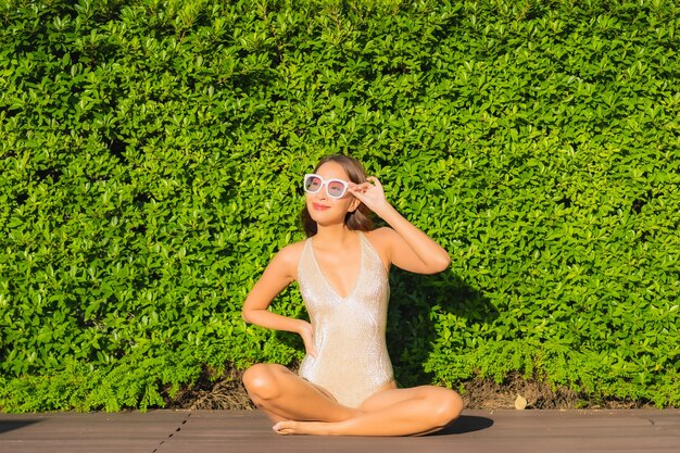 Portrait de la belle jeune femme asiatique se détendre autour de la piscine extérieure dans l'hôtel resort