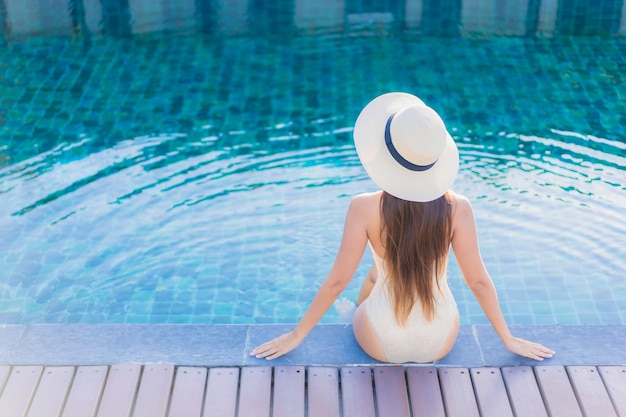 Portrait de la belle jeune femme asiatique se détendre autour de la piscine extérieure dans l'hôtel resort