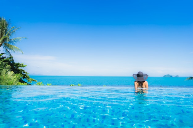 Photo gratuite portrait belle jeune femme asiatique se détendre dans la piscine extérieure de luxe dans l'hôtel resort près de la mer