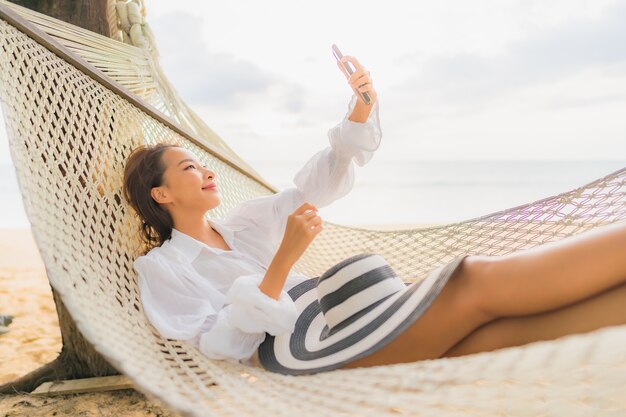 Portrait de la belle jeune femme asiatique se détendre sur un hamac autour de la plage en vacances