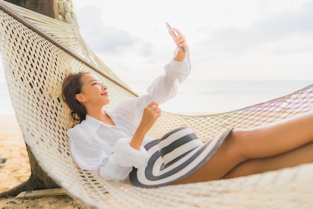 Portrait de la belle jeune femme asiatique se détendre sur un hamac autour de la plage en vacances