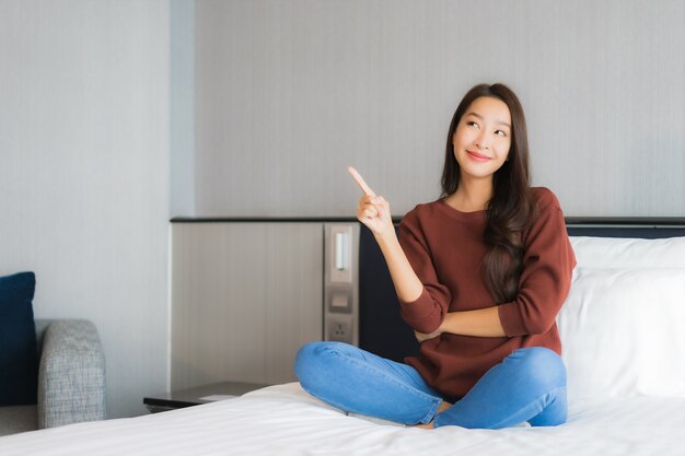 Portrait belle jeune femme asiatique se détendre sur le lit à l'intérieur de la chambre