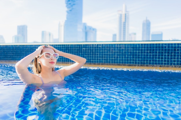 Portrait belle jeune femme asiatique se détendre les loisirs profiter autour de la piscine extérieure