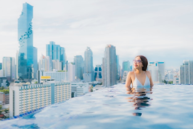 Portrait belle jeune femme asiatique se détendre loisirs sourire heureux autour de la piscine extérieure