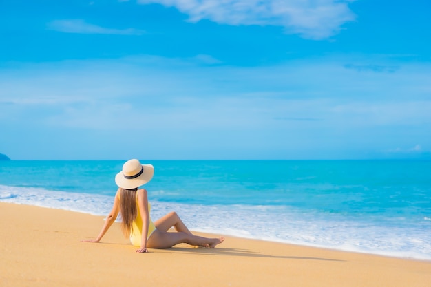 Portrait de la belle jeune femme asiatique se détendre sur la plage en vacances de voyage