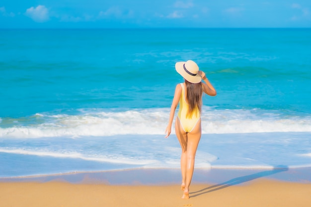 Portrait de la belle jeune femme asiatique se détendre sur la plage en vacances de voyage