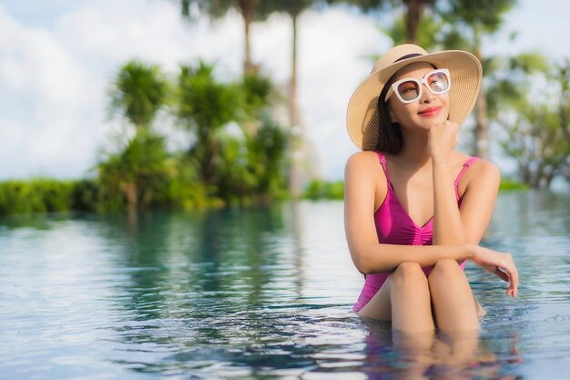 Portrait belle jeune femme asiatique se détendre profiter de la piscine extérieure en vacances