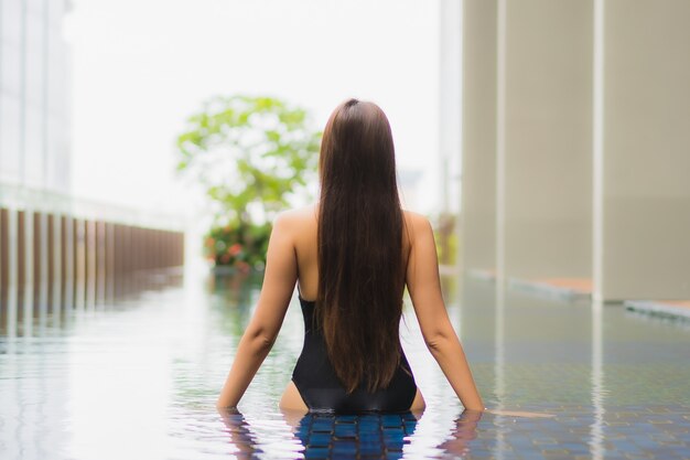 Portrait belle jeune femme asiatique se détendre sourire autour de la piscine extérieure dans l'hôtel resort