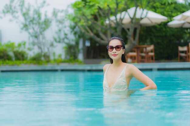 Portrait belle jeune femme asiatique se détendre sourire autour de la piscine extérieure