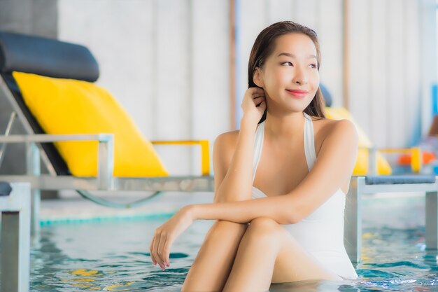 Portrait belle jeune femme asiatique se détendre sourire autour de la piscine de l'hôtel resort en vacances de voyage