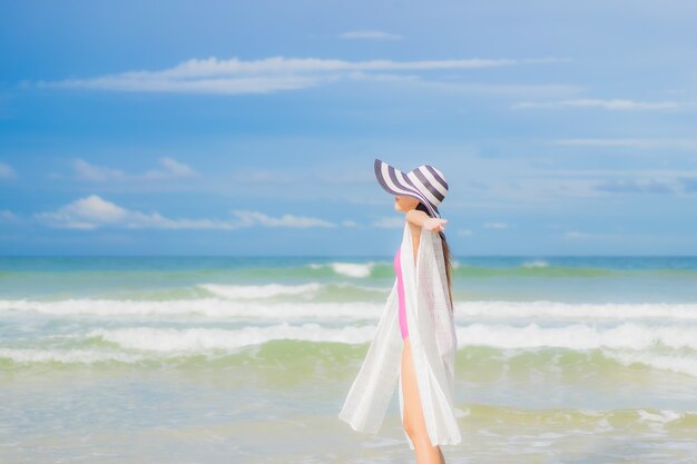 Portrait belle jeune femme asiatique se détendre sourire autour de la plage mer océan en vacances vacances voyage voyage