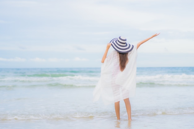 Portrait belle jeune femme asiatique se détendre sourire autour de la plage mer océan en vacances vacances voyage voyage