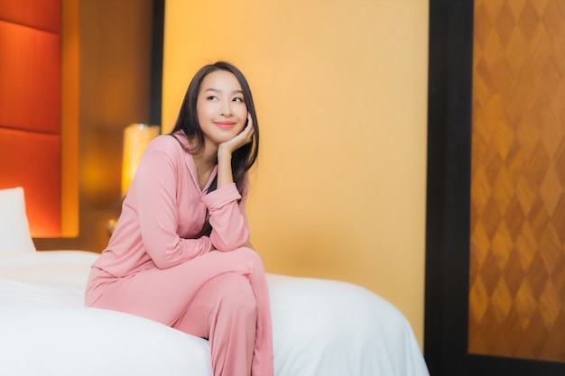 Portrait belle jeune femme asiatique se détendre sourire heureux sur le lit à l'intérieur de la chambre