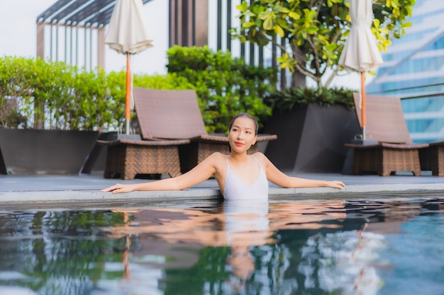 Portrait belle jeune femme asiatique se détendre sourire loisirs autour de la piscine extérieure
