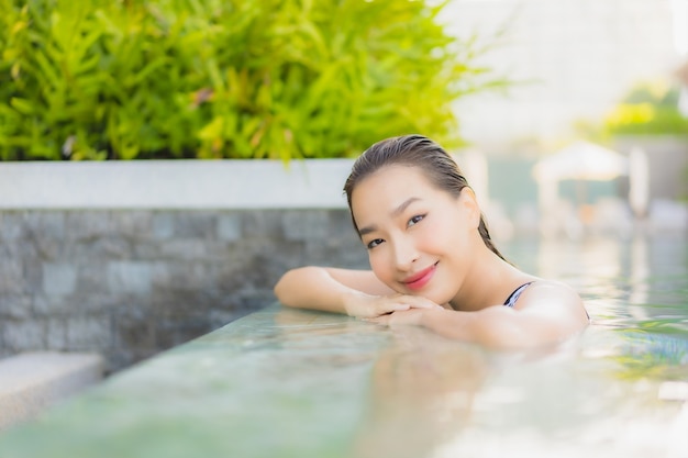 Portrait belle jeune femme asiatique se détendre sourire loisirs autour de la piscine extérieure