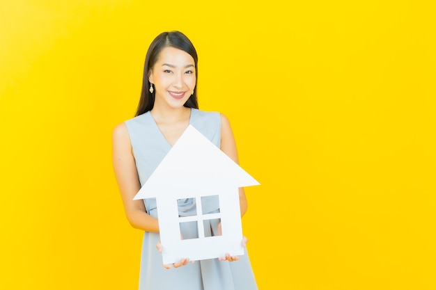 Portrait belle jeune femme asiatique avec signe de papier maison ou maison